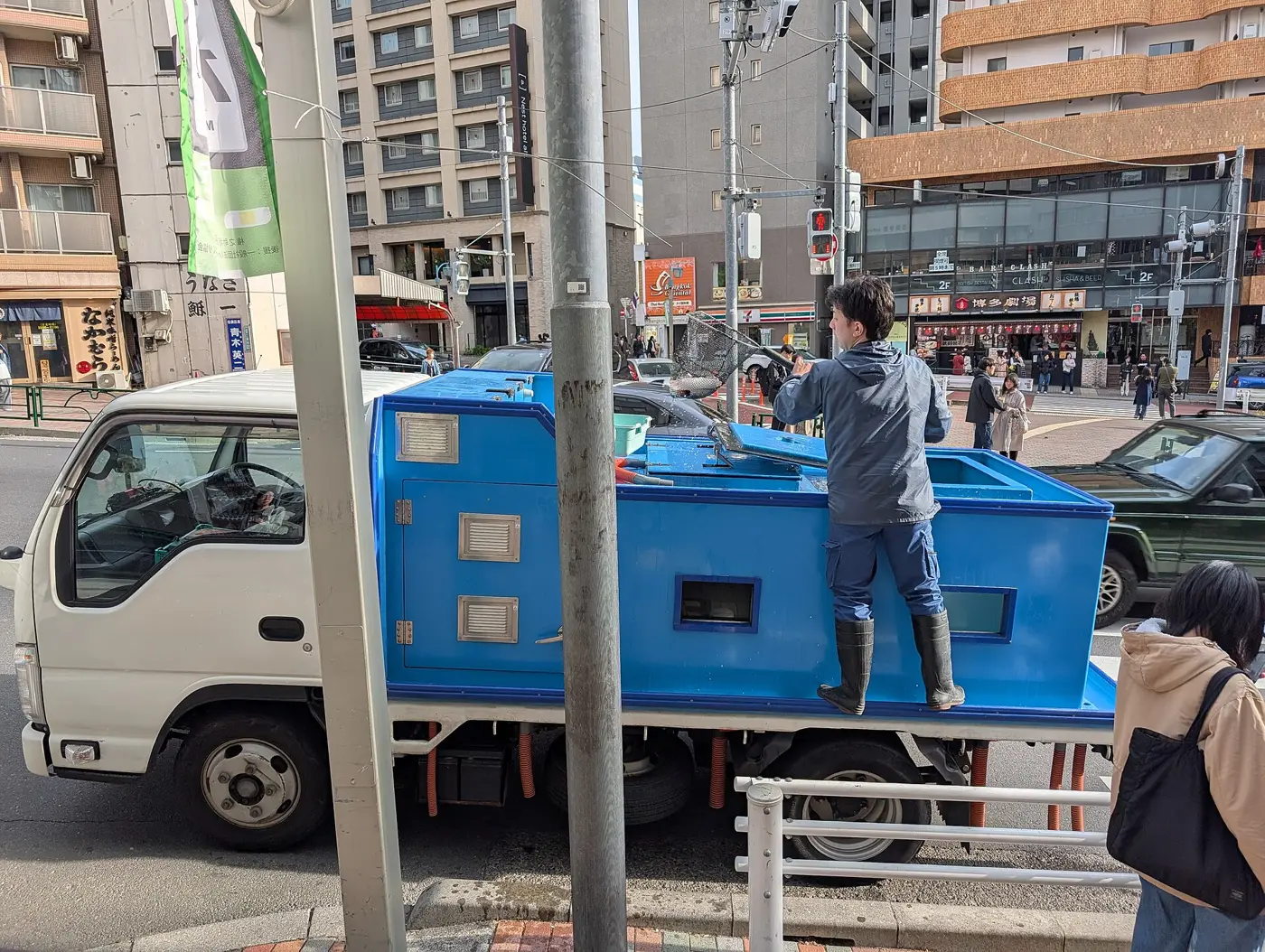 街なかで荷台の作業をするトラックと作業員
