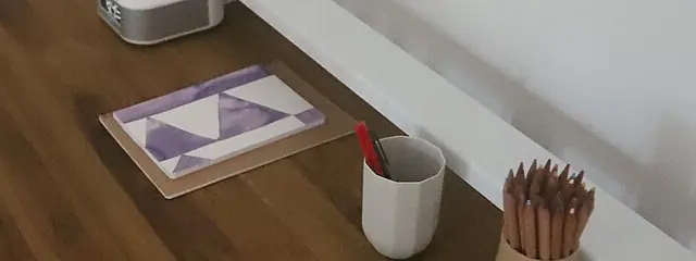 ノートと色鉛筆が置かれた木の机